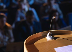 Close up of podium with speaker in auditorium
